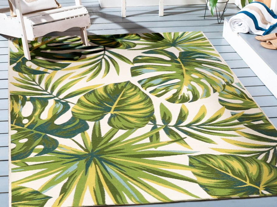 green palm leaf print area rug on a deck