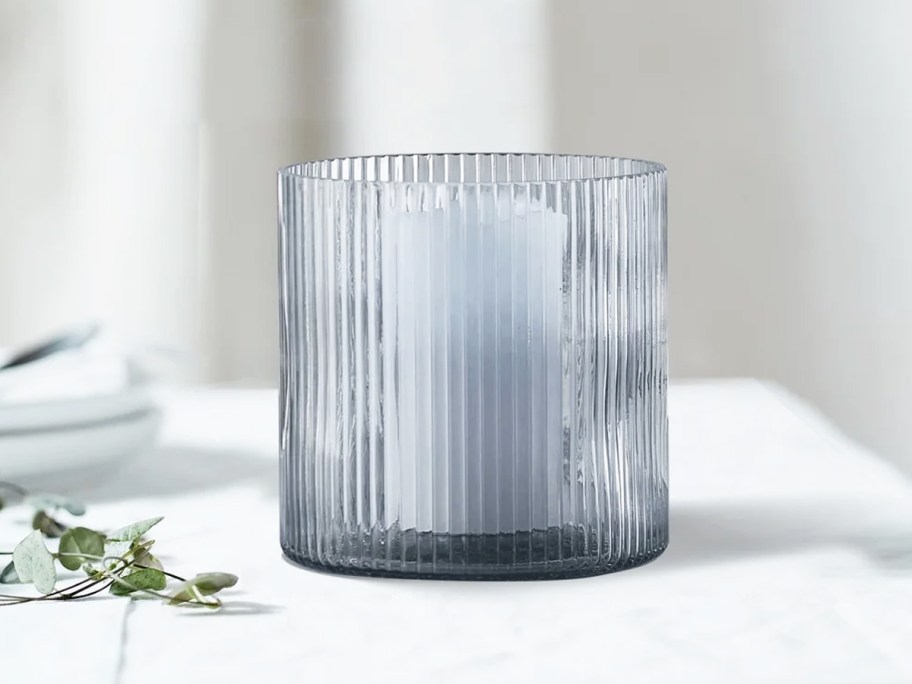 small blue ribbed glass candle holder on white table
