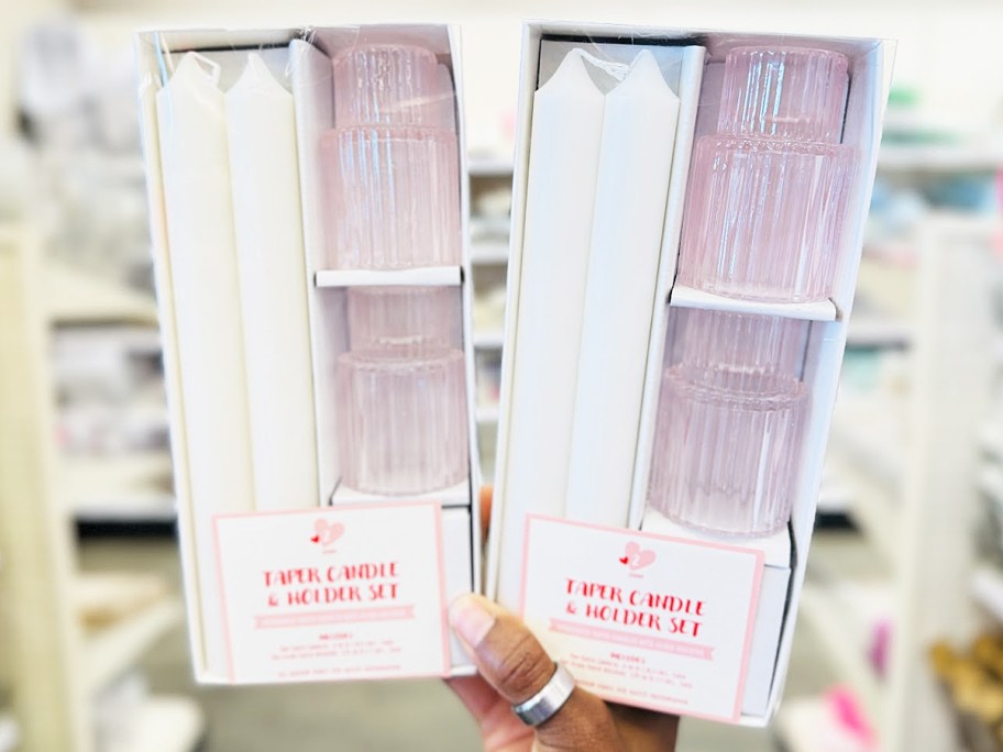 hand holding up taper candle sets