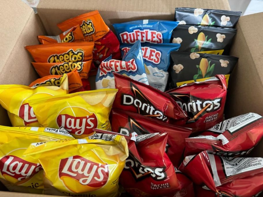 frito lays, doritos, cheetos, ruffles, and smartfood popcorn bags in a delivery box