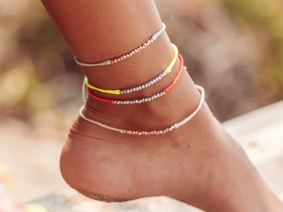 foot with multiple beaded anklets