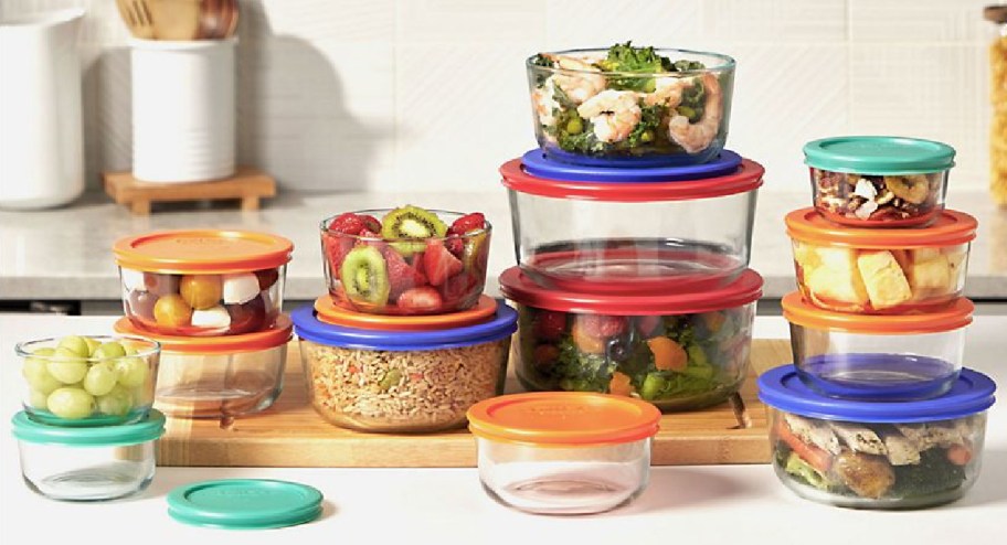 Pyrex Simply Store 28-Piece Glass Food Storage Set displayed on top of a counter with food inside of it