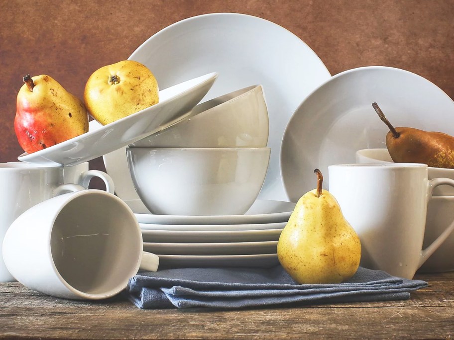 stack of white plates, bowls, and mugs with pears