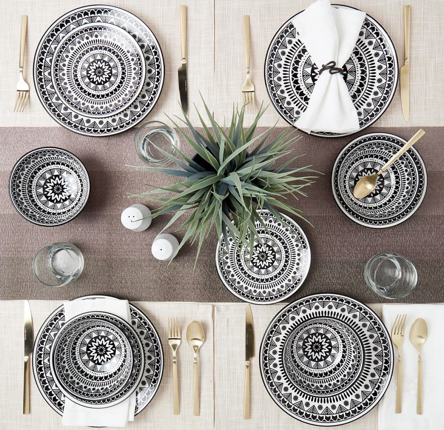 table set with black and white printed plates and bowls