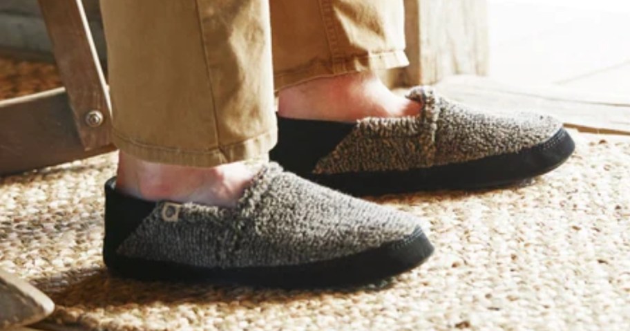 a man's lower legs and feet, he's wearing khaki pants and grey wool slippers