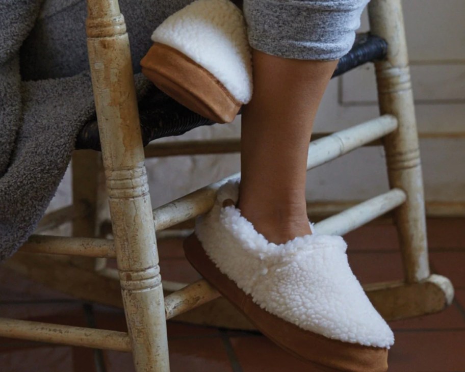 white slippers on feet on wooden chair