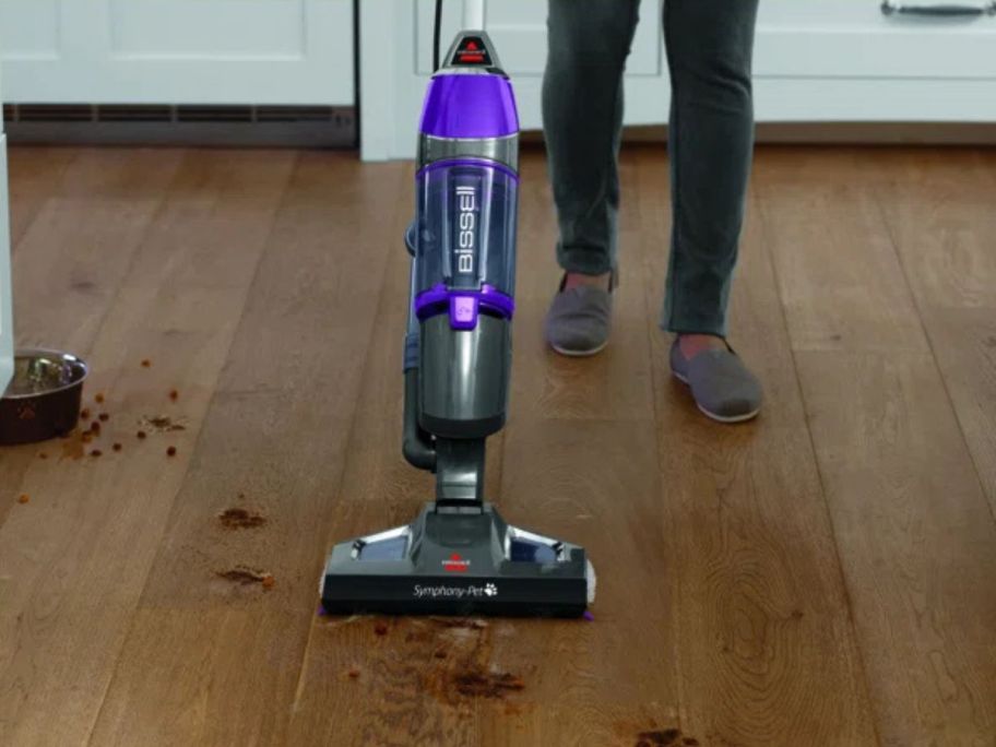 person using bissell steam mop on floor with muddy paw prints