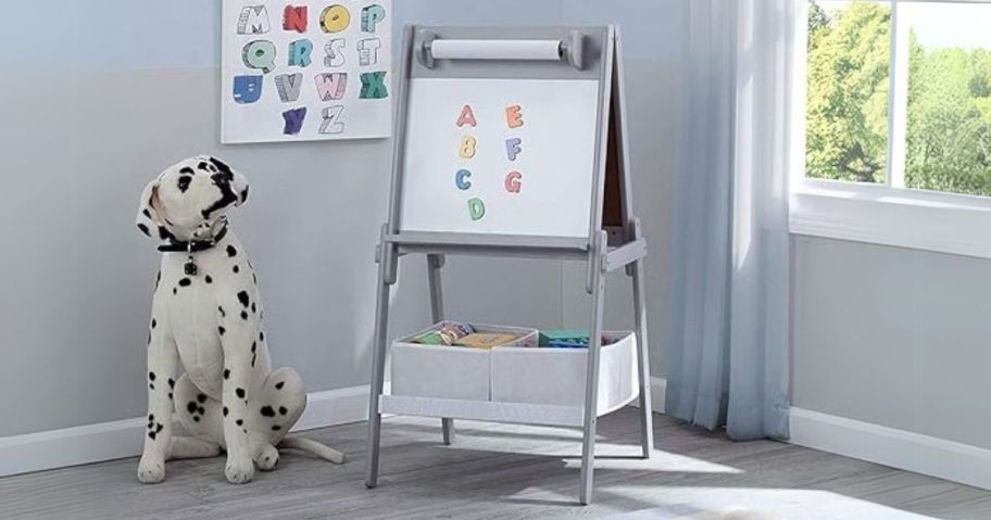 grey Delta Children Activity Easel with alphabet magnets on it in play room