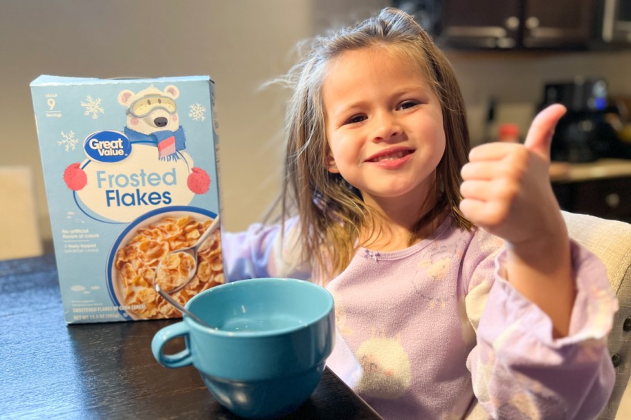 girl eating frosted flakes cereal with thumbs up