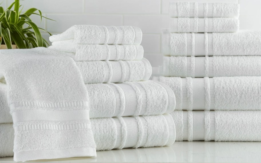 white towels, wash cloths, and hand towels stacked on table