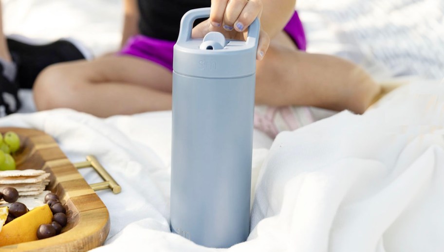 hand holding blue water bottle