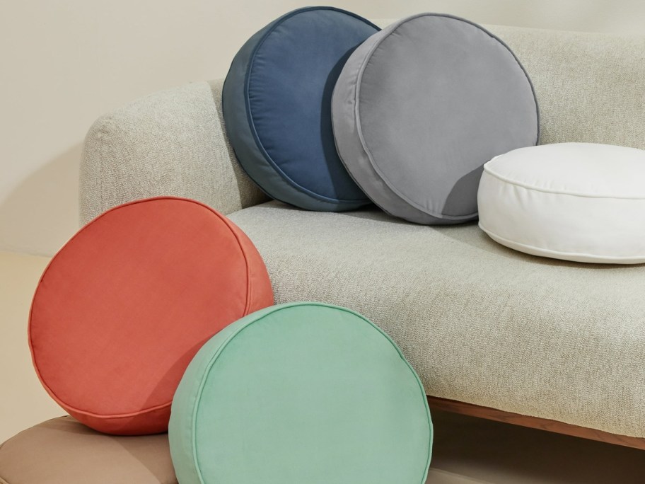 round throw pillows in different colors on and beside of a couch