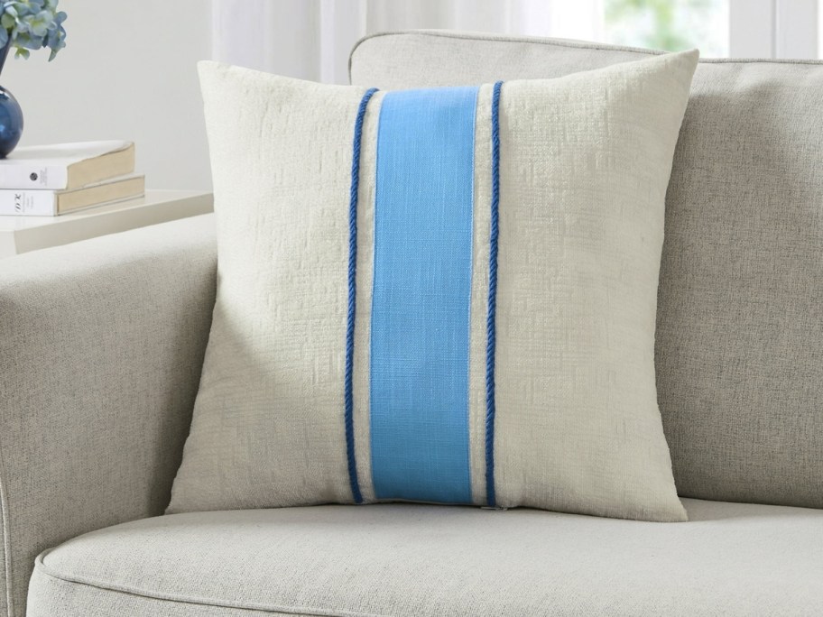 a tan and blue stripe throw pillow on a couch