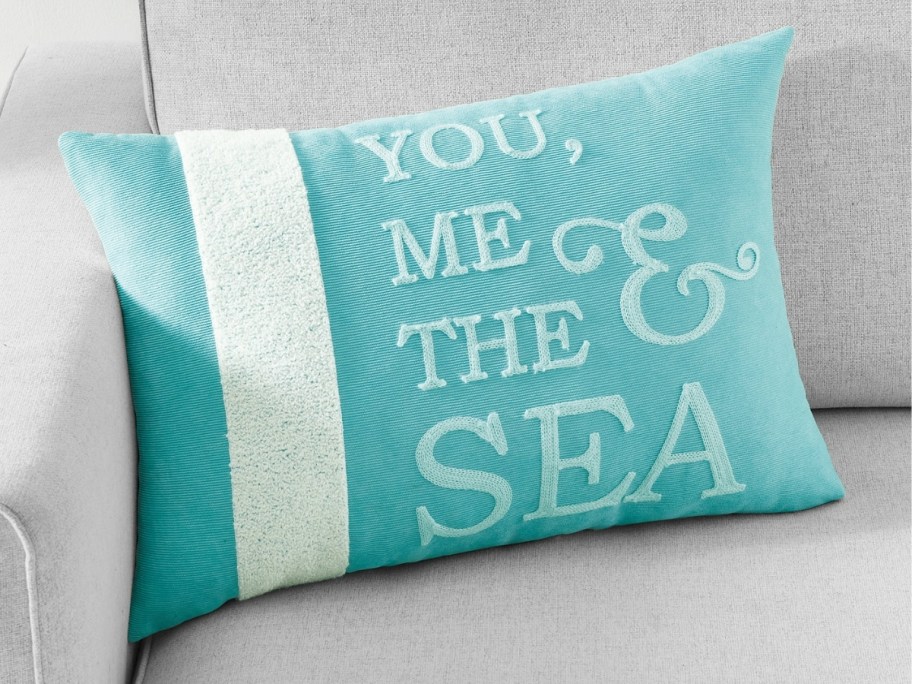 a coastal throw pillow on a couch that says "you, me, and the sea"
