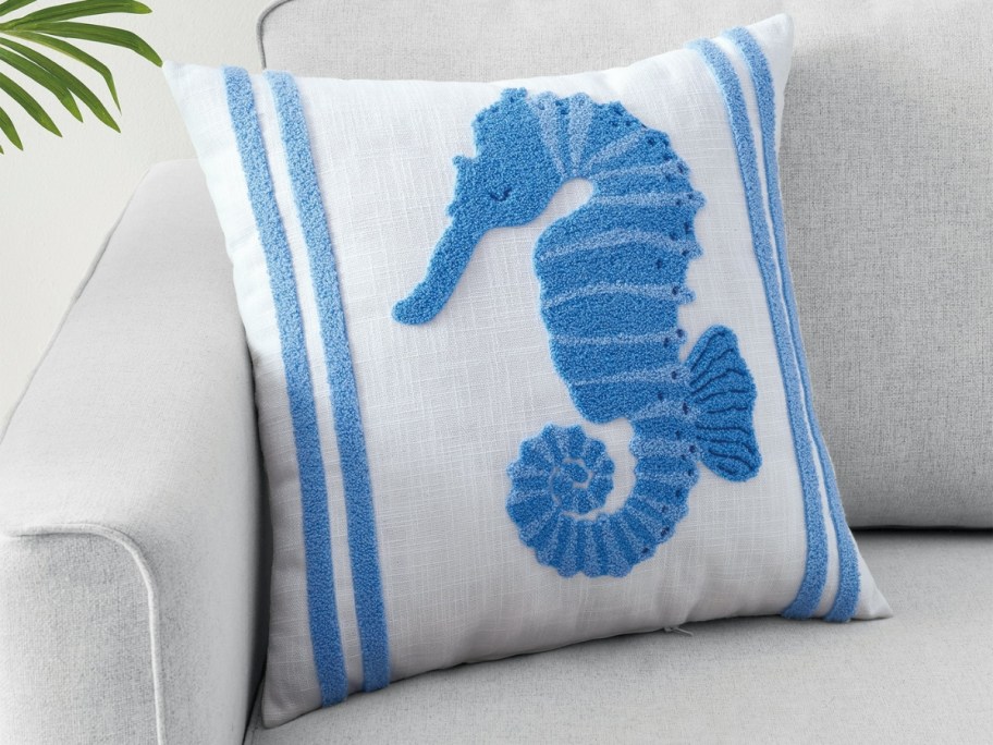 a seahorse throw pillow on a couch