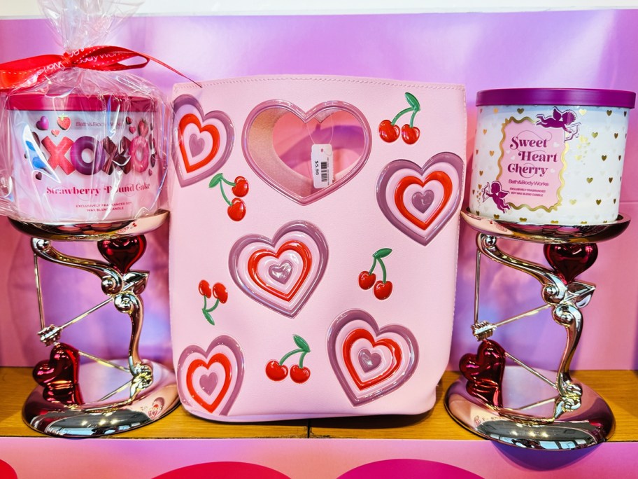 pink heart gift bag in the middle of two valentines candle holders