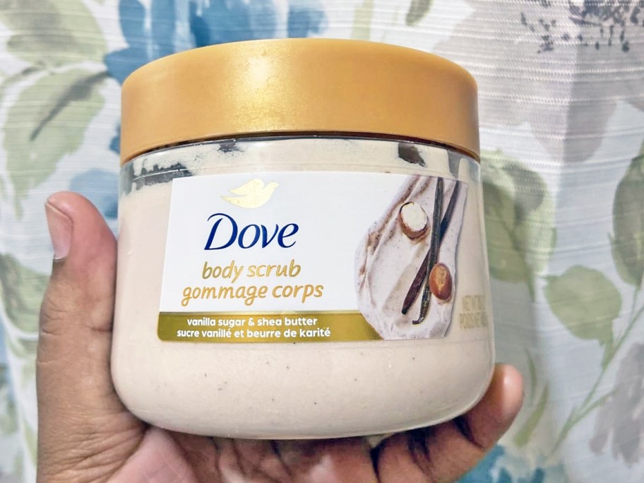 hand holding up a jar of Dove Body Scrub in Vanilla Sugar & Shea Butter scent