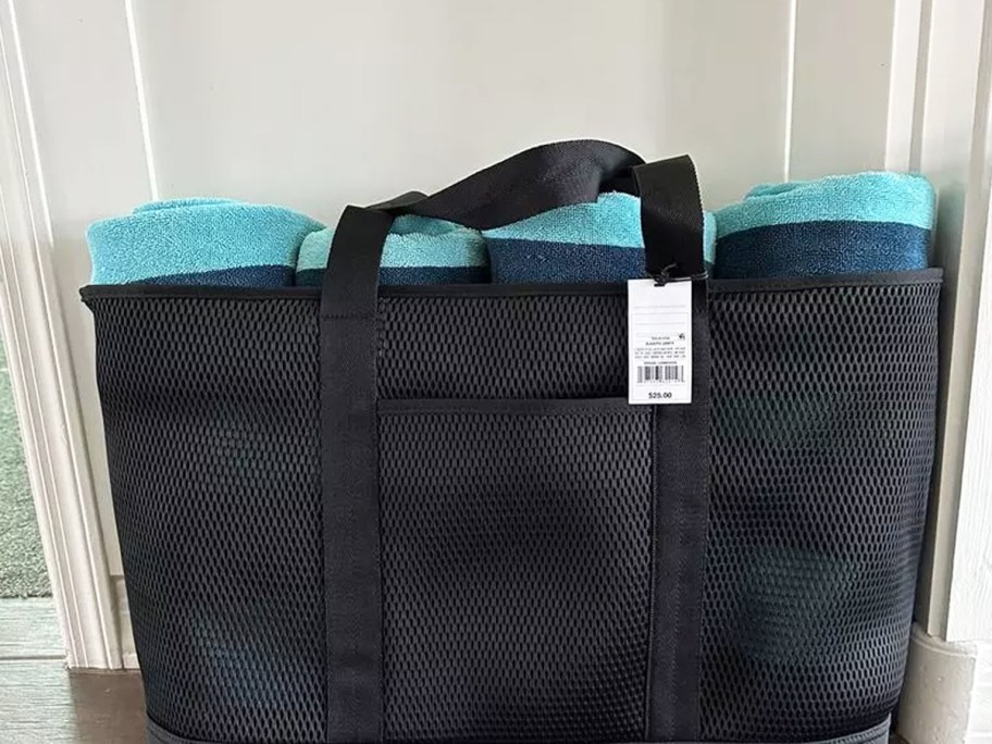 blue beach towels rolled up inside a black tote bag