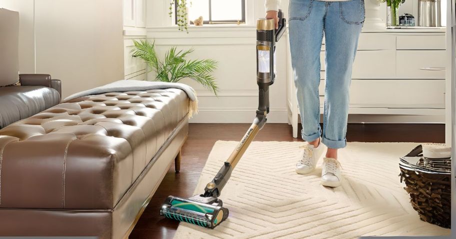 person using Shark PowerDetect Cordless Stick Vacuum w/ Tools & Reverse Clean to vacuum underneath couch