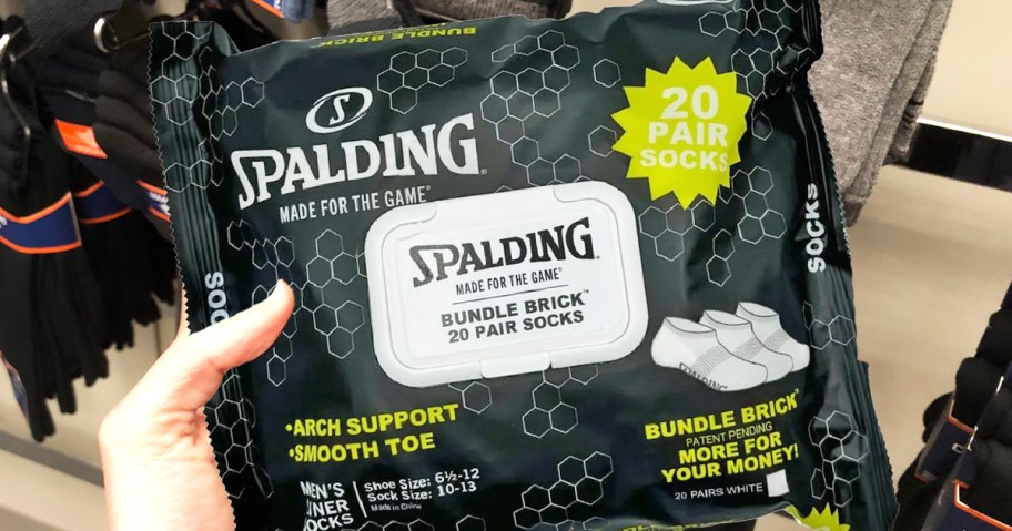 hand holding a black package of Spalding Socks