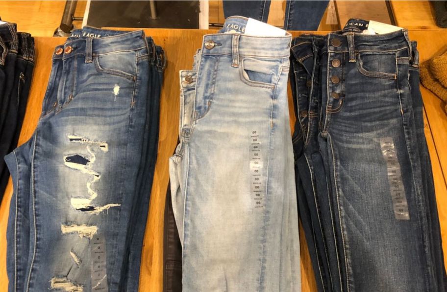 3 pair of american eagle jeans on a display table o a store