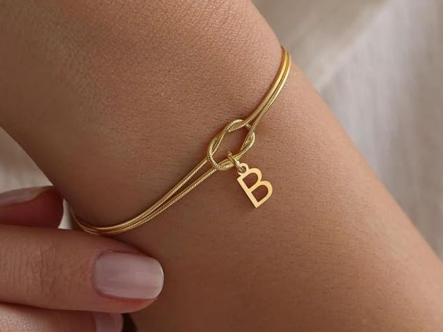 woman wearing gold Decholly Initial Charm Bracelet on wrist
