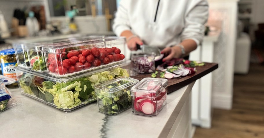 chopping veggies on a cutting board for fridge prep 