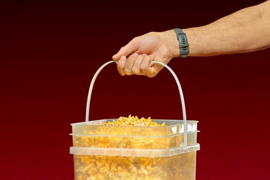 hand holding a clear bucket of popcorn