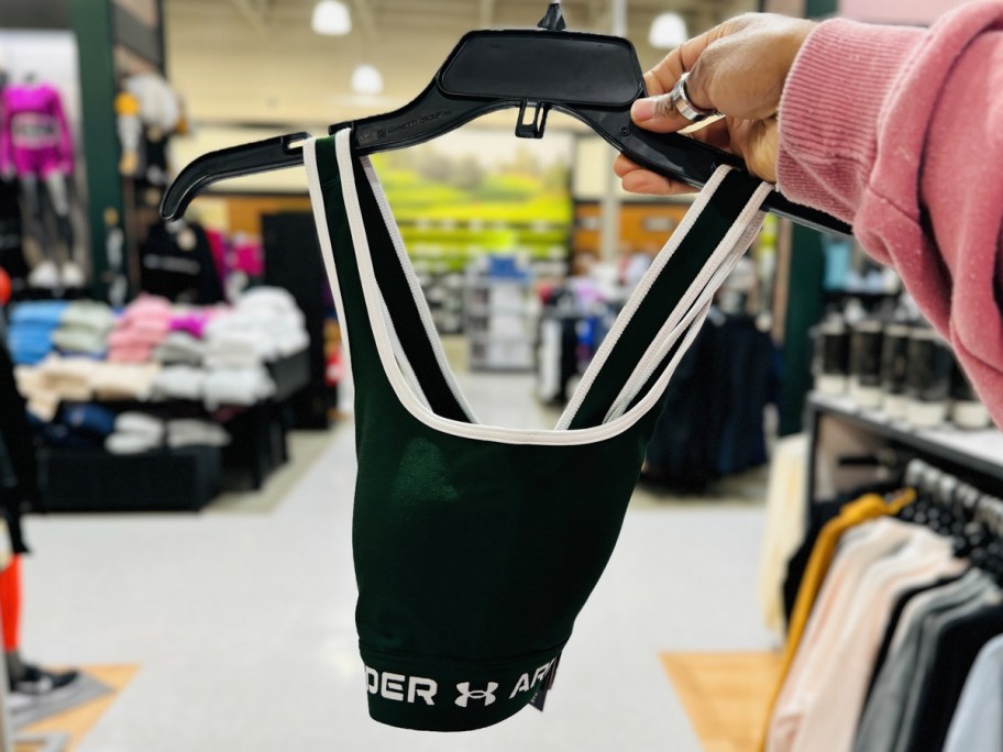 hand holding green under armour sports bra