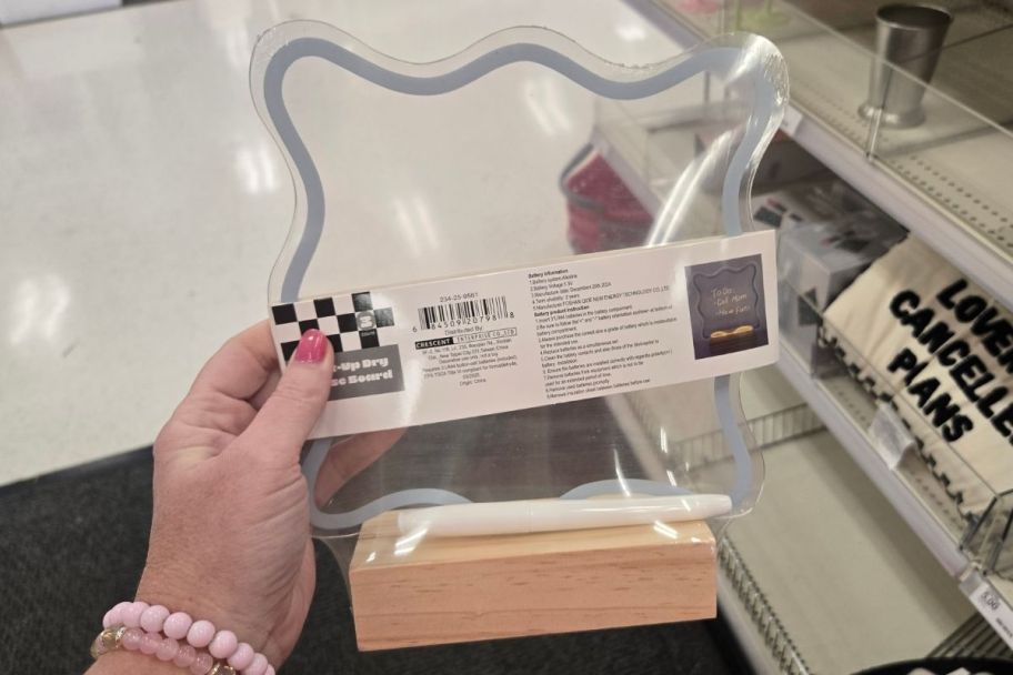 a womans hand holding an acrylic light up dry erase board.