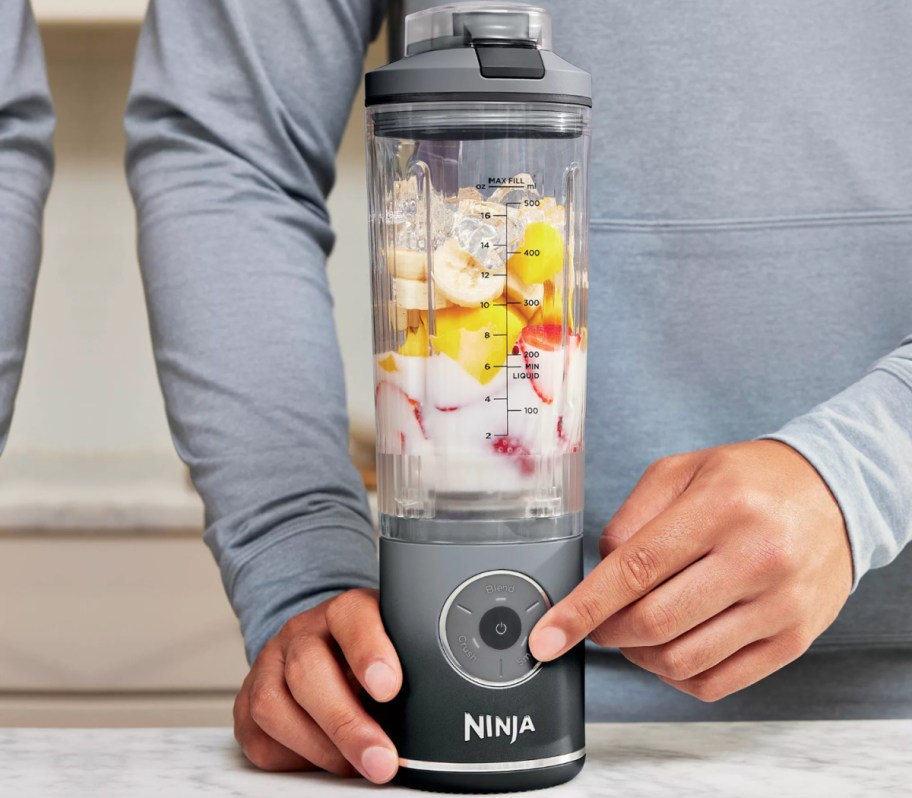 hand pushing ninja blender button