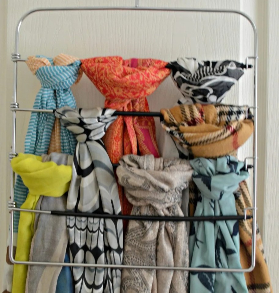 metal pant hanger with scarves hanging from it