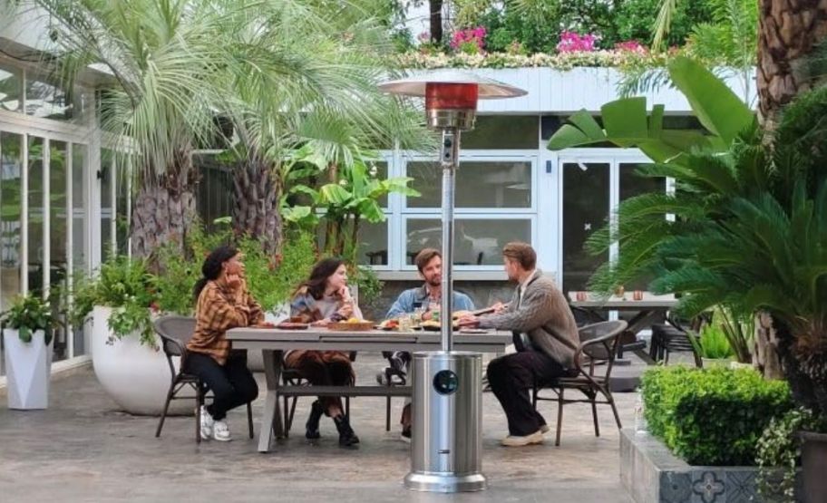 a patio heater on a patio with a table of 4 people in the background