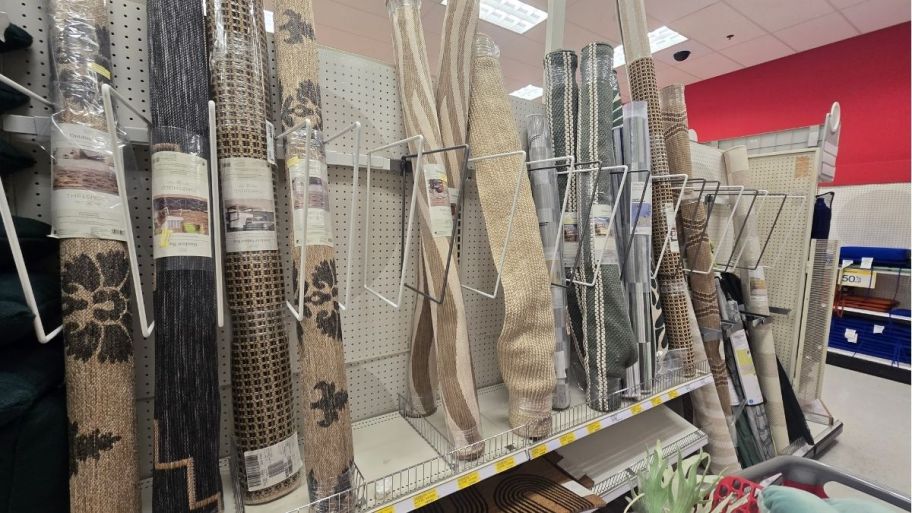 various rolled up rugs displayed on a store aisle