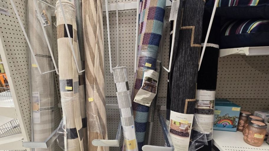 Target rugs in rolls on a display wall in a store