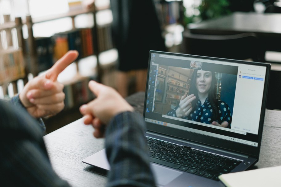 person translating sign language on laptop 
