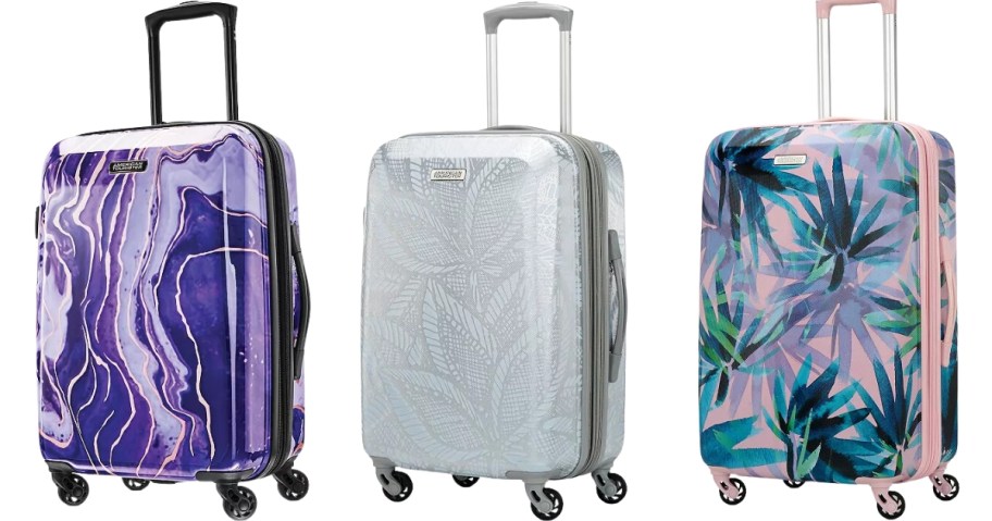 3 carryon rolling spinner luggage pieces, one is purple print, one is a silver print, and one is pink with palm trees