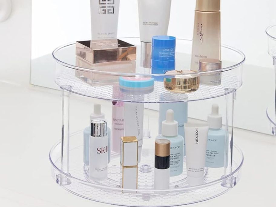 A plastic Lazy Susan turntable in a cabinet with cosmetics on it 
