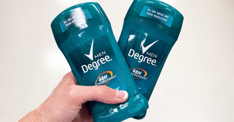 hand holding two blue sticks of degree deodorant 