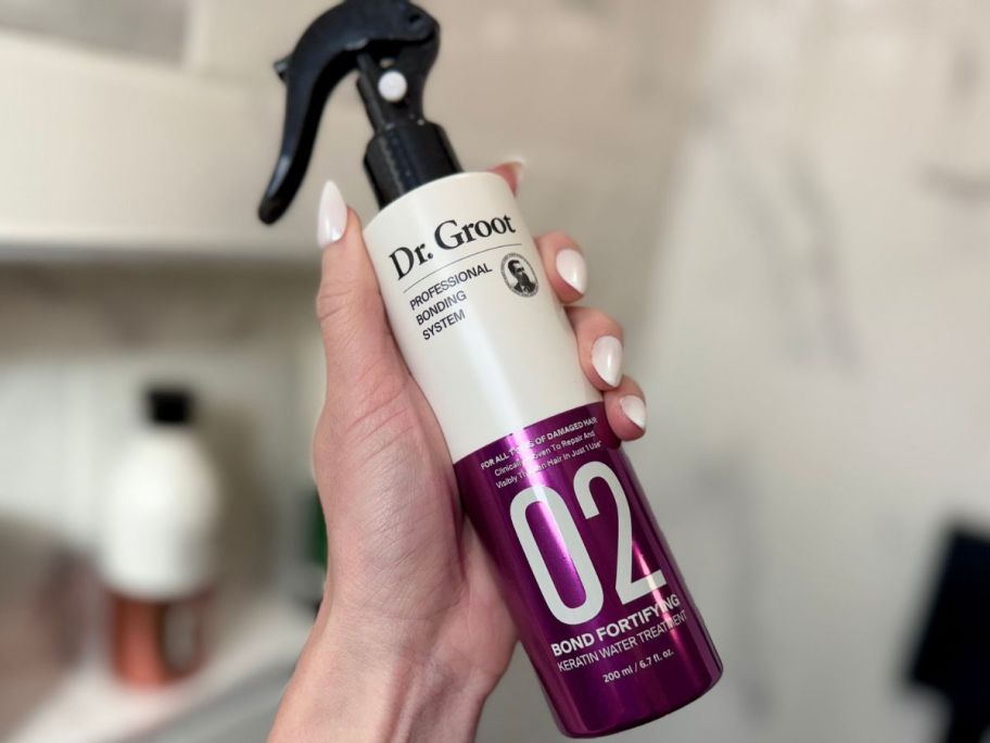 Hand holding a bottle of Dr. Groot Professional Bonding System #2 Keratin Water 