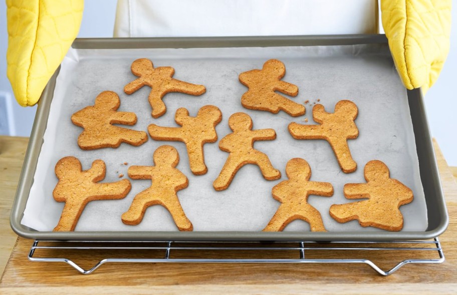 hand holding a baking sheet full of ninja shaped cookies