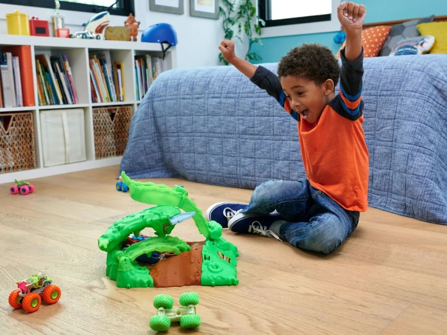 Little boy playing with a Hot Wheels Monster Trucks Arena Smashers Glow-in-the-Dark Gunkster & Truck Set