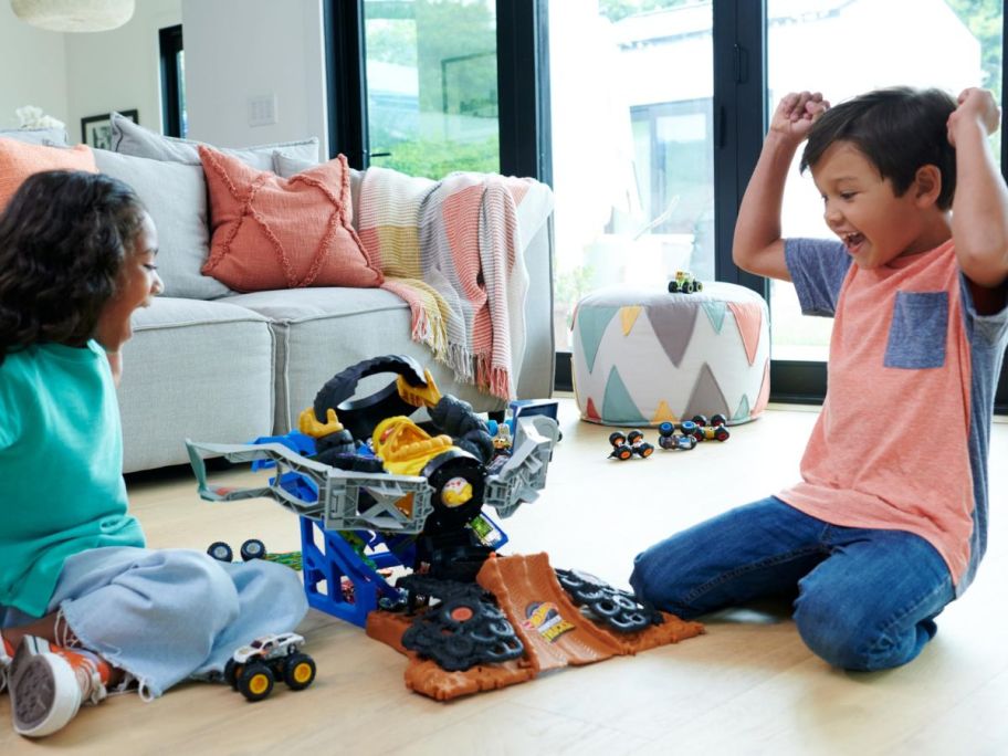 Two kids playing with a Hot Wheels Monster Trucks Arena Smashers Mega-Wrex Vs. Crushzilla Takedown Playset