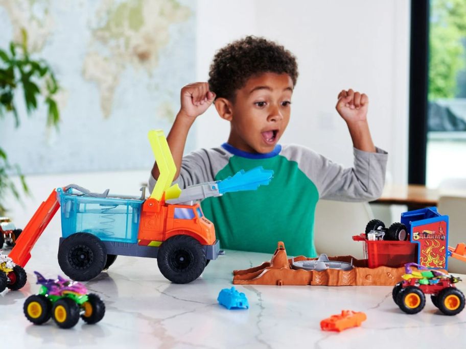 little boy playing with Hot Wheels Monster Trucks Arena Smashers Color Shifters 5-Alarm Rescue Playset