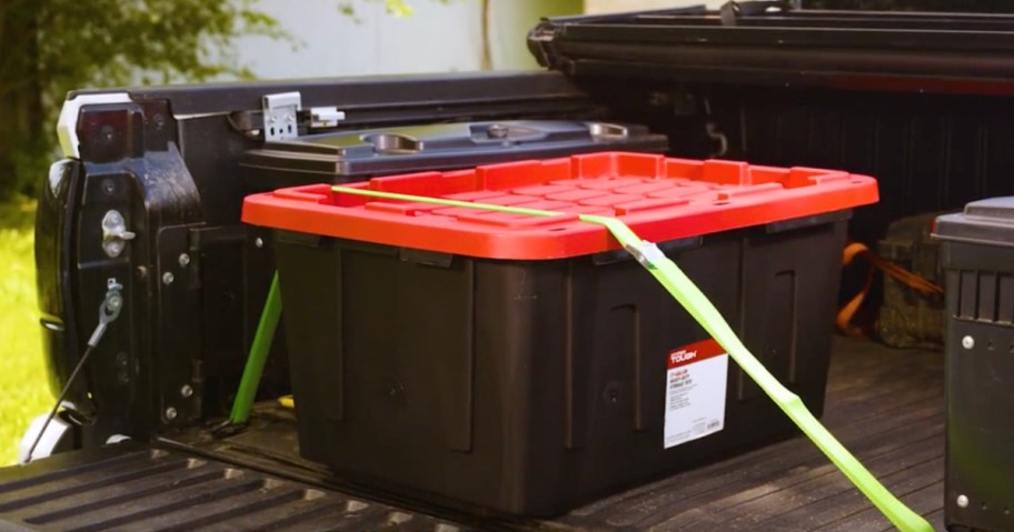 Black and red storage box harnessed down in the bed of pick up truck
