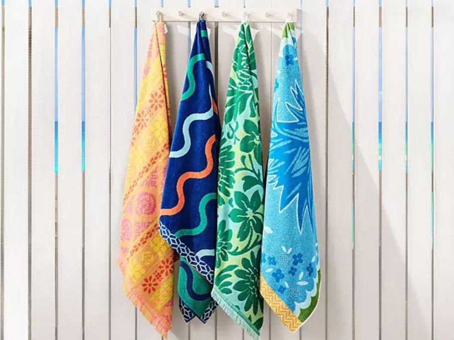4 Member's Mark Oversized Beach Towels hanging on a fence