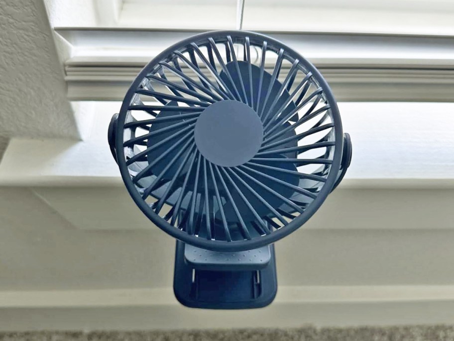 blue fan clipped on windowsill 
