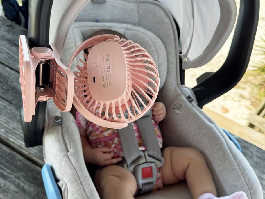 pink fan clipped on car seat