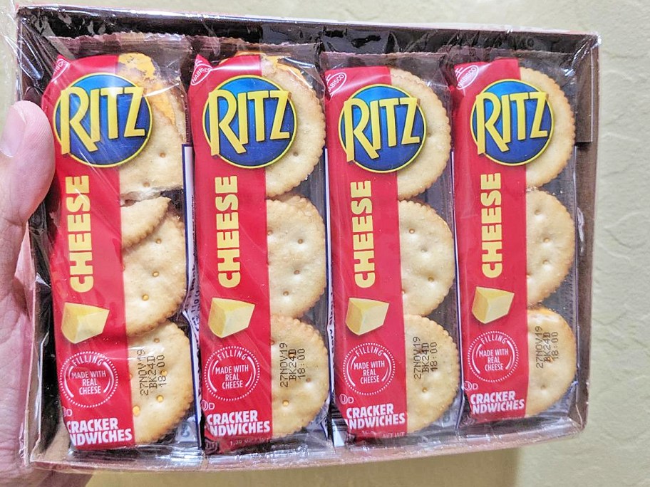 hand holding up a box of RITZ Cheese Sandwich Crackers