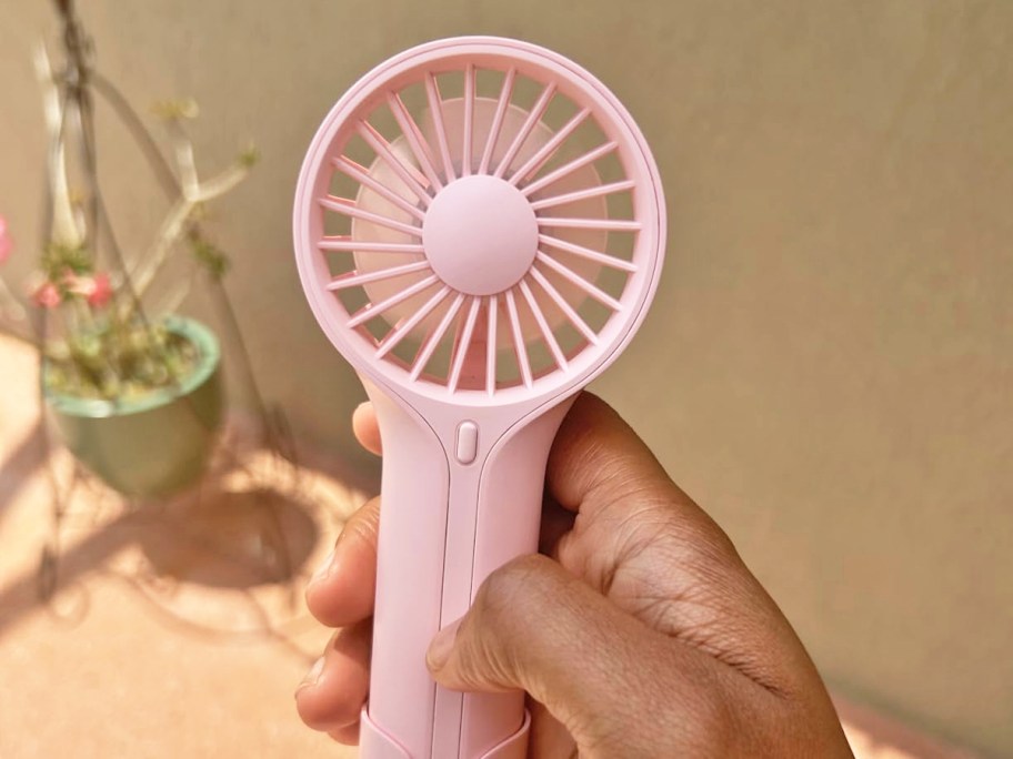 hand holding a pink personal fan